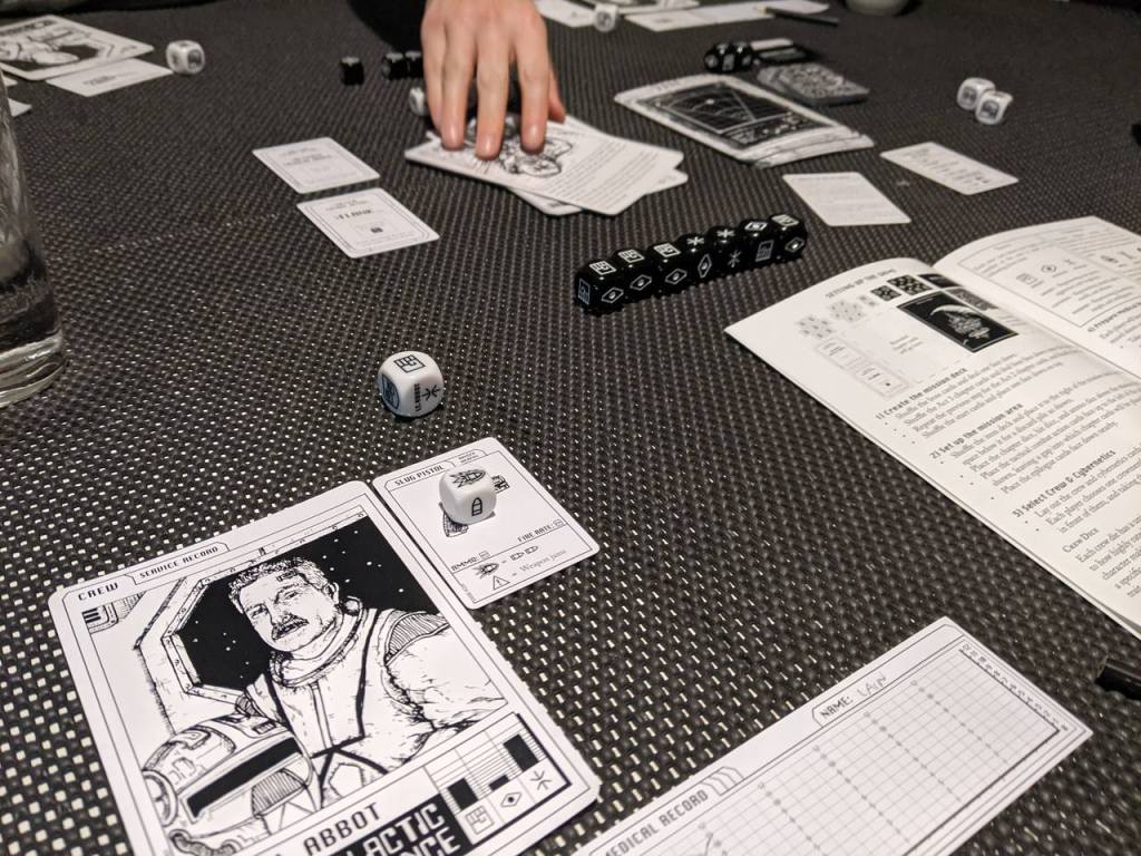 The game in play showing an encounter card, bullet dice, skill dice and chapter dice. 